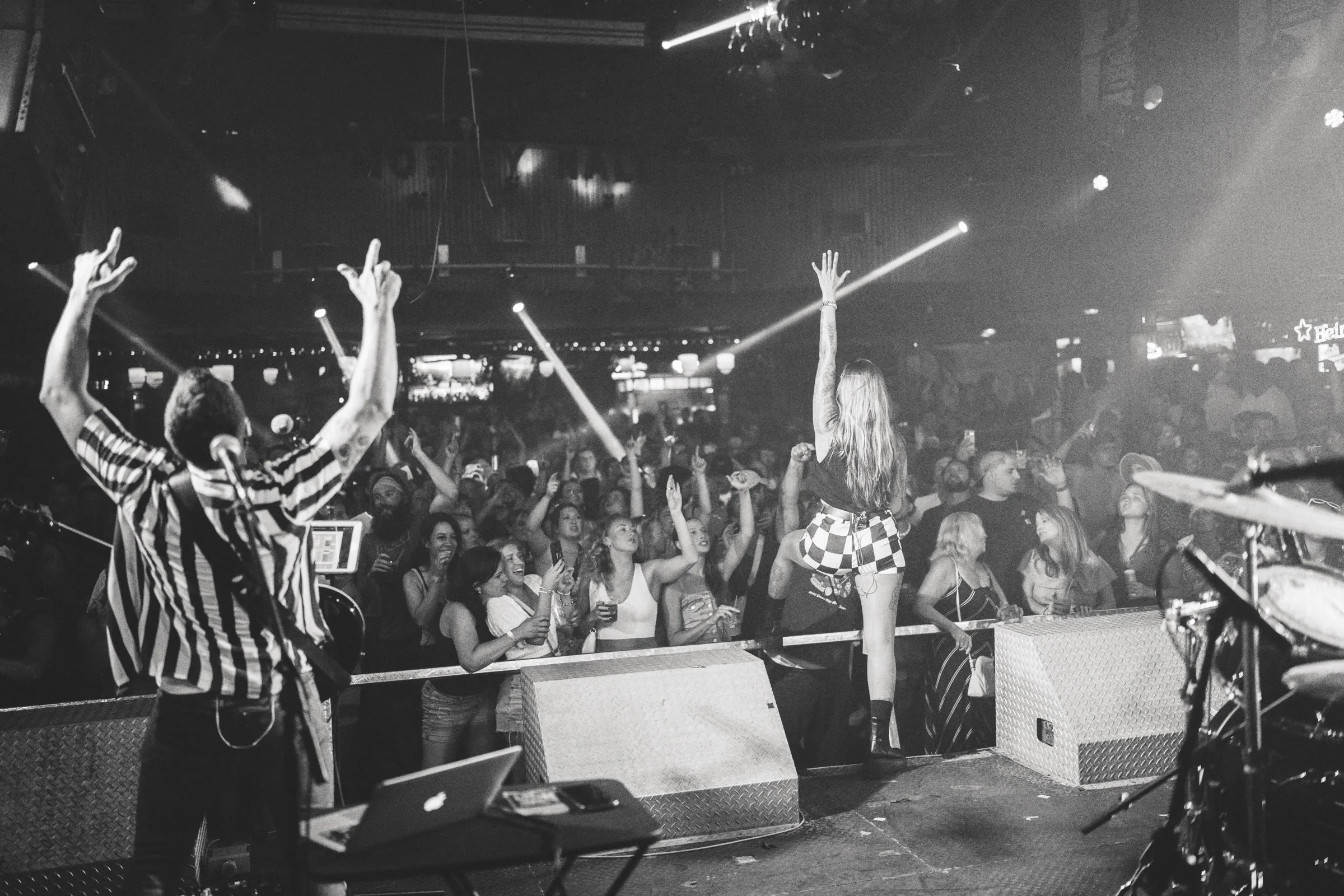 Noah Spott on stage with The Benderz, arms raised toward a crowded venue
